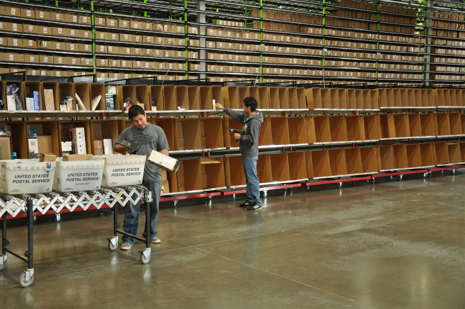 Warehouse sorting area with rolling pick bins and stocked shelving